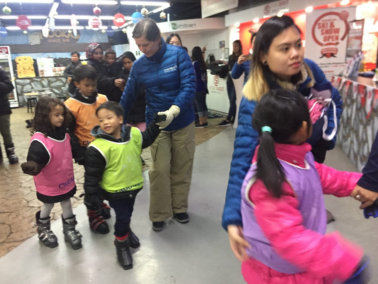 An instructor coaching children in the snow