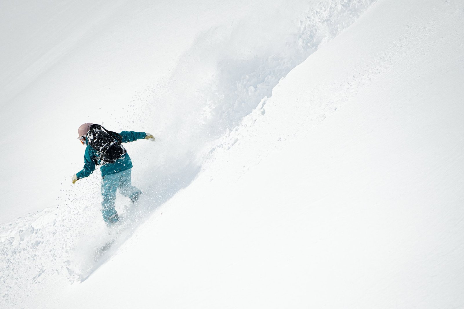 Snowboarder carving through powder