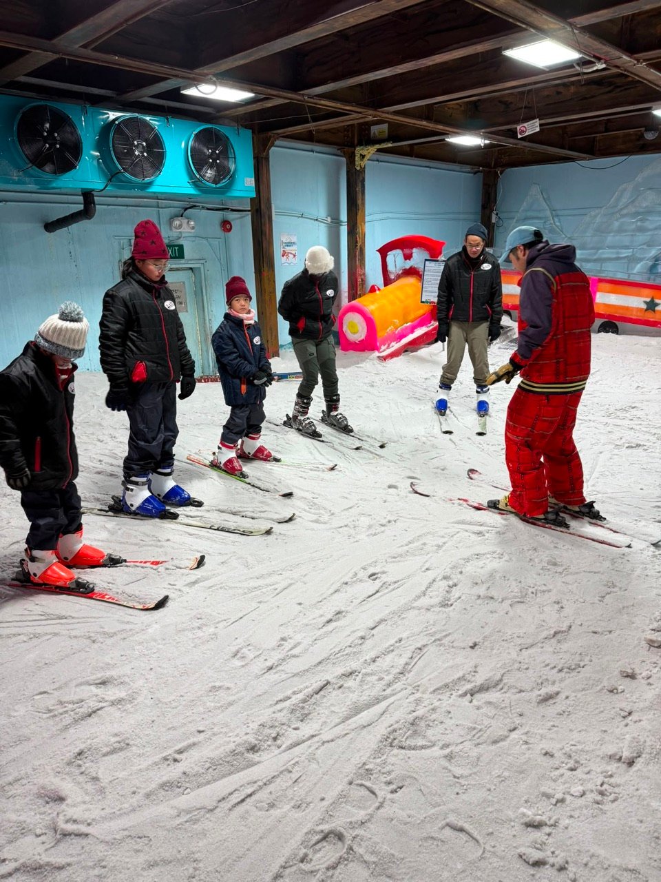 Children in a beginner ski lesson at Snowcity's indoor snow arena